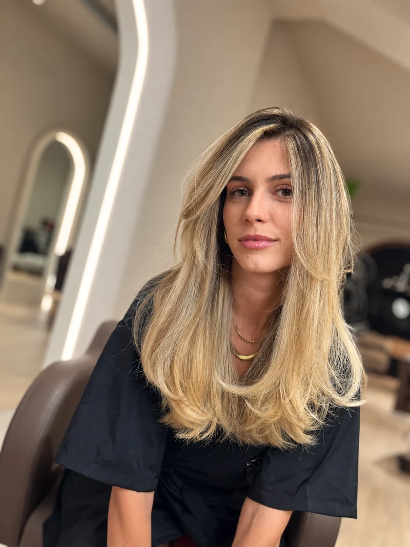 Cliente com madeixas loiras e raiz natural, fotografada no salão em Coimbra